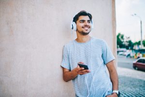 Cheerful,Hipster,Blogger,Listening,Electronic,Music,In,Modern,Headphones,Connected